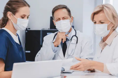 Medicos reunidos conversando em uma mesa